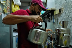An Indian tea seller who gave his name as Rafik pours karak in Dubai, United Arab Emirates, Aug. 24, 2022.