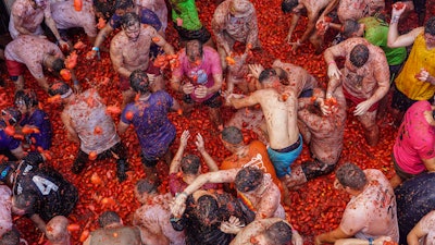 Revellers throw tomatoes at each other during the annual 'Tomatina' tomato fight fiesta, Buñol, Spain, Aug. 31, 2022.