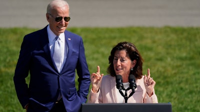 President Joe Biden looks on as Secretary of Commerce Gina Raimondo speaks before the signing of the 'CHIPS and Science Act of 2022' on the South Lawn of the White House, Aug. 9, 2022.