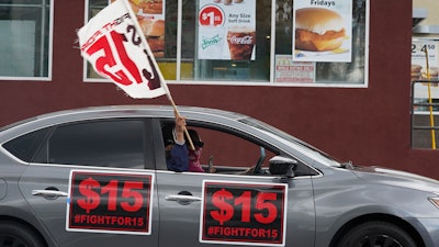 Fast food workers drive though a McDonald's restaurant demanding a $15 hourly minimum wage, East Los Angeles, Calif., March 12, 2021.
