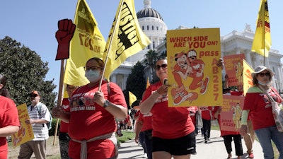 Fast food workers and supporters march past the California state Capitol, Sacramento, Aug. 16, 2022.