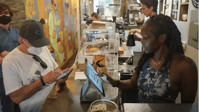 Kymme Williams-Davis, right, takes orders at the Bushwick Grind Café, New York, Sept. 8, 2022.