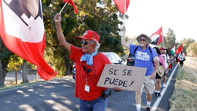 Asunción Ponce, left, marches with fellow members of the United Farm Workers near Walnut Grove, Calif., Aug. 24, 2022.