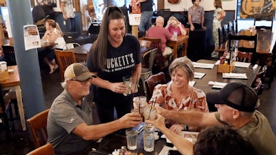 Macy Norman, center, serves a table of guests at Puckett's Grocery and Restaurant, Sept. 10, 2021, Nashville.
