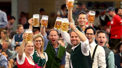 Visitors lift glasses of beer during the opening of the 186th Oktoberfest beer festival in Munich, Sept. 21, 2019.