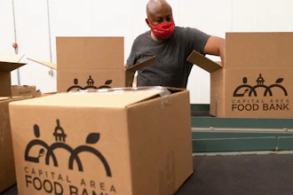 A volunteer pack boxes of food at The Capital Area Food Bank in Washington, Oct. 5, 2021.