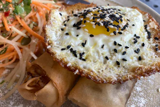 A vegan chorizo egg roll and a meat chorizo egg roll topped with a fried egg and a papaya and carrot slaw, BOCA restaurant, Tucson, Ariz., Oct. 14, 2022.