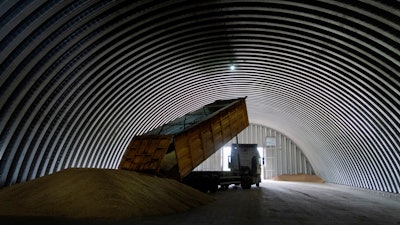 A dump track unloads grain in a granary, Zghurivka, Ukraine, Aug. 9, 2022.