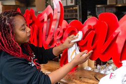 Pinky Cole, the owner of Slutty Vegan restaurants and food trucks, wipes down a sign on her storefront in Atlanta, May 20, 2020.