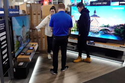 A Best Buy employee helps customers with television selection, Nov. 26, 2021, Indianapolis.