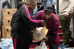 Ricardo Barrett accepts a turkey from volunteer Rita James, left, during a food giveaway at The Redeemed Christian Church of God New Wine Assembly, Washington, Nov. 22, 2022.