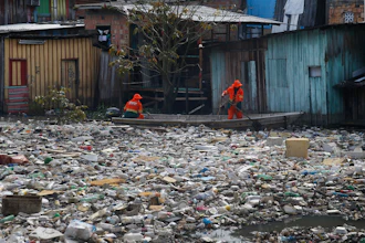 City workers remove garbage floating on the Negro River, Manaus, Brazil, June 6, 2022.