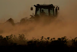 Dust flies as a farmer plows over a failed cotton field, Oct. 4, 2022, Halfway, Texas.