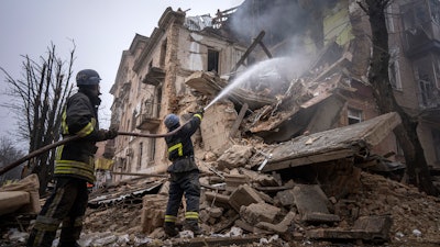 Ukrainian State Emergency Service firefighters work to extinguish a fire at the building which was destroyed by a Russian attack in Kryvyi Rih, Dec. 16, 2022.