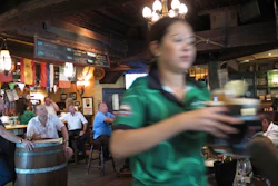 A waitress serves customers beer at a restaurant in Dubai, June 22, 2016.