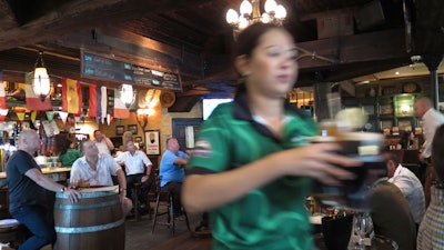 A waitress serves customers beer at a restaurant in Dubai, June 22, 2016.