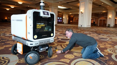 A member of the media films the Ottobot Yeti as it operates before the start of the CES tech show, Jan. 4, 2023, Las Vegas.