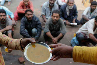 People wait for free food outside an eatery in Ahmedabad, India, Jan. 20, 2021.