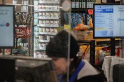 A cashier at a Gristedes supermarket in view of a freezer holding Haagen-Dazs ice cream, New York, Jan. 31, 2023.
