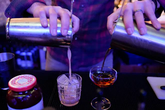 Gregory Megner, general manager and mixologist at Baltimore Spirits Company, pours two drinks, Feb. 8, 2023, Baltimore.