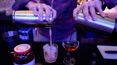 Gregory Megner, general manager and mixologist at Baltimore Spirits Company, pours two drinks, Feb. 8, 2023, Baltimore.