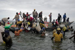 Fishermen swim out from an incoming boat in Gazi Bay, Kenya, June 12, 2022.