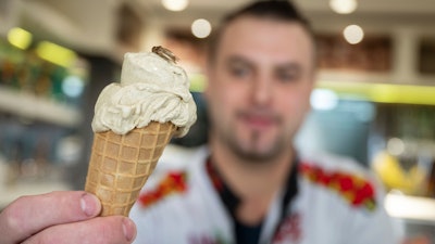 Thomas Micolino, owner of Eiscafe Rino, holds an ice cream cone in Rottenburg am Neckar, Germany, March 1, 2023.