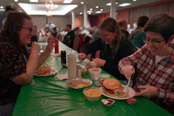 From left, Laura Kuster, Miranda Crotsley and Hollen Barmer eat fish sandwiches, homemade perogies, and macaroni and cheese at the St. Maximilian Kolbe Catholic Church fish fry in Pittsburgh, Feb. 24, 2023.