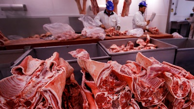 Butchers prepare cuts of meat at Smithfield Market in London, July 18, 2016.