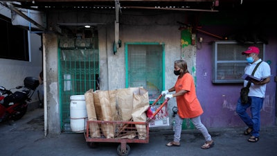 Marilene Capentes pushes her cart along the streets of Malabon, Philippines, Feb. 13, 2023.