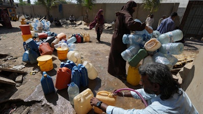 People get drinking water from a water collecting point in Karachi, Pakistan, March 21, 2023.