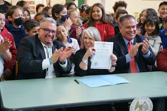 New Mexico Gov. Michelle Lujan Grisham holds a bill signed at Pinon Elementary School in Santa Fe, N.M., March 27, 2023.