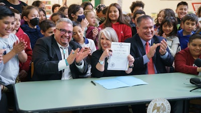 New Mexico Gov. Michelle Lujan Grisham holds a bill signed at Pinon Elementary School in Santa Fe, N.M., March 27, 2023.