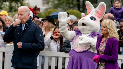 President Joe Biden, accompanied by first lady Jill Biden, blows his whistle for the start of a race during the White House Easter Egg Roll, April 18, 2022, Washington.