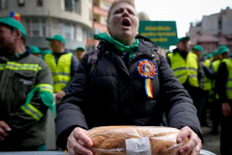 A woman holds a loaf of bread during a farmers' protest in front of the Representative Office of the European Commission, Bucharest, Romania, April 7, 2023.