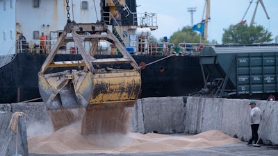 Workers load grain at a port in Izmail, Ukraine, April 26, 2023.