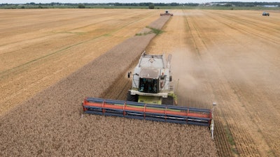 Harvesters collect wheat in Zghurivka, Ukraine, Aug. 9, 2022.