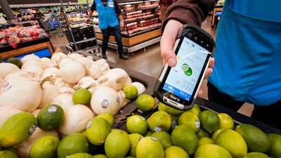 A worker scans onions, limes and other produce in a Walmart Supercenter in North Bergen, N.J., Feb. 9, 2023.