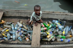 A child sits inside a canoe with empty plastic bottles he collected to sell for recycling in the floating slum of Makoko, Lagos, Nigeria, Nov. 8, 2022.