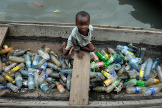 A child sits inside a canoe with empty plastic bottles he collected to sell for recycling in the floating slum of Makoko, Lagos, Nigeria, Nov. 8, 2022.
