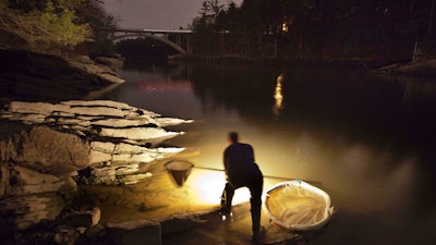 Bruce Steeves uses a lantern to look for young eels n a river in southern Maine, March 23, 2012.