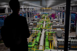 A person looks out at the pipeline that transports seawater to filters at a desalination plant in Barcelona, May 16, 2023.