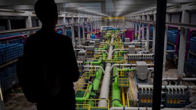 A person looks out at the pipeline that transports seawater to filters at a desalination plant in Barcelona, May 16, 2023.