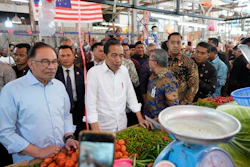 Indonesian President Joko Widodo, center, with Malaysian Prime Minister Anwar Ibrahim at a wet market in Kuala Lumpur, June 8, 2023.