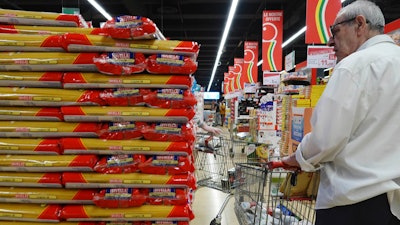 Customers look at packages of pasta in a supermarket in Milan, June 8, 2023.