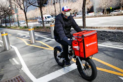A delivery worker rides his bicycle along a path on the West Side Highway in New York, March 16, 2020.