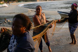 Greyla Aguilera and her coworkers carry a net on the coast of Chuao, Venezuela, June 8, 2023.