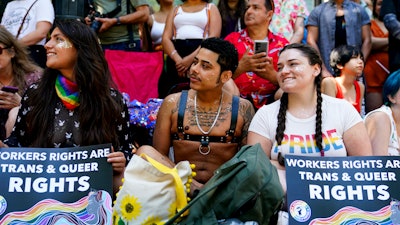 Jessica Garcia, Erik Garcia and Meara White hold signs in support of Starbucks workers at the annual Seattle Pride Parade, June 25, 2023.