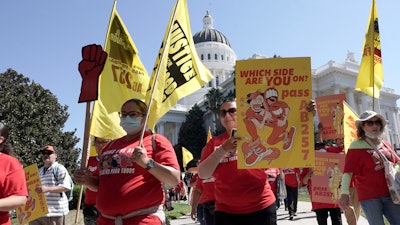 Fast food workers and their supporters march past the California state Capitol in Sacramento, Aug. 16, 2022.