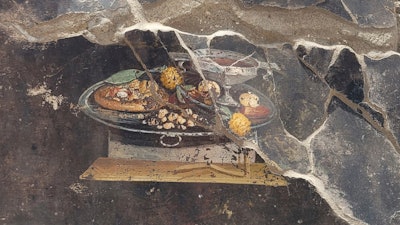 A fresco, depicting a table with food, on the wall of an ancient Pompeian house.